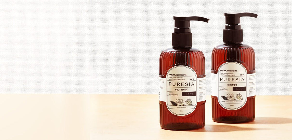 PURESIA body wash and shampoo bottles on a warm wooden surface